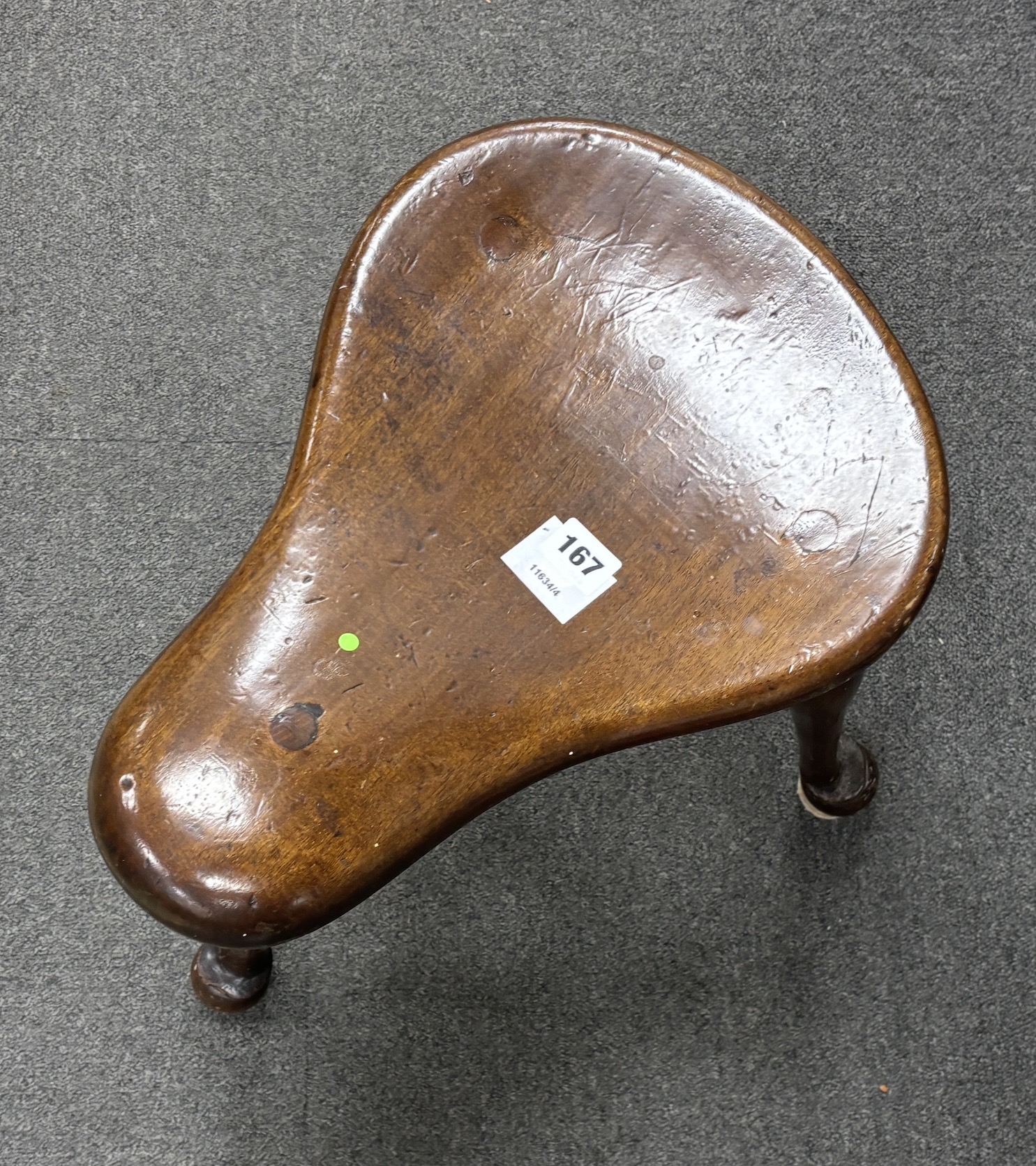 A George III style mahogany saddle seat three legged stool, width 41cm, depth 41cm, height 42cm